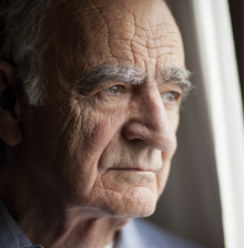 Elderly gentleman gazing out a window