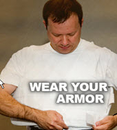 Wear Your Armor (picture of a man putting on body armor)