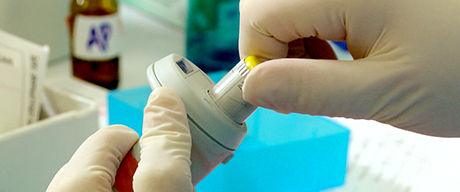 Photo of a swab from a sexual assault kit inserted into a test tube for testing by a crime lab scientist.