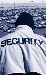 Image of security guard looking down at a parking lot.