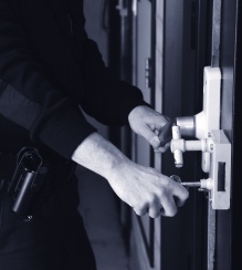 Officer's hands locking a cell door.