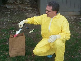 Image of evidence technician placing evidence in paper bag