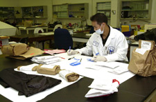 Photo of scientist at table with bags of DNA Evidence