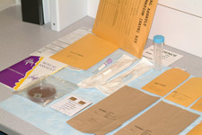 Photo of a table with multiple evidence manila folders, as well as test tubes on it.