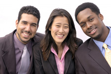 Photo of three diverse people in suits smiling
