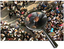 Aerial photo of large group of people, with a magnifying glass over one man in the crowd