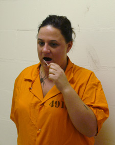 Photo of a female prisoner swabbing the inside of her cheek with a cotton swab