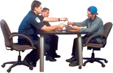 Photo of police interrogation where police are handing suspect a pen