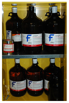 Image of labelled bottles of chemicals in a cabinet
