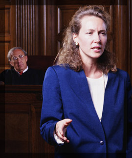 Photo of a female attorney speaking in a courtroom in front of a judge