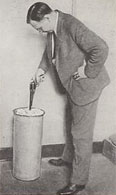 Photo of Calvin Goddard firing a gun into a cylindrical container
