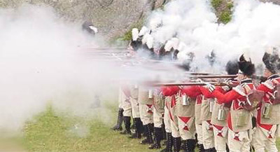 Photo of Revolutionary war red coated soldiers firing guns in a line