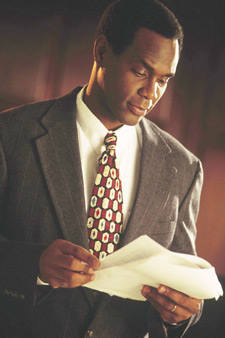 Photo of a man in a suit reading a document