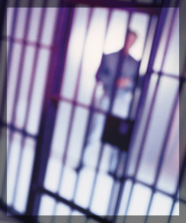 Photo of an officer in front of a jail cell. 