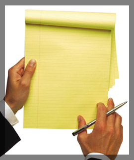 Photo of a person holding a pen and a legal notepad