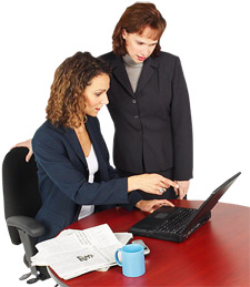 Photo of two women look at a laptop