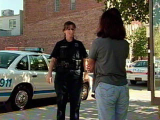 Photo of officer interviewing woman for a domestic violence complaint.