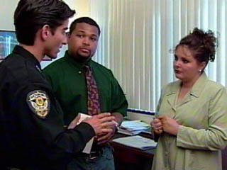 Photo of law enforcement officer interviewing parent at school