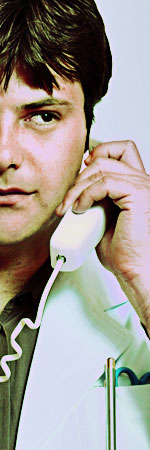 Photo of a man on a wired telephone