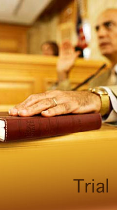 Photo of a male witness placing his hand on a book before testifying. Caption reads, 'Trial'