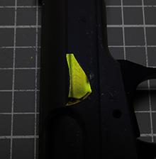A fragment from a magneto-optical sensor, originally developed for medical purposes, reveals an obliterated serial number on a gun when viewed through a polarized filter