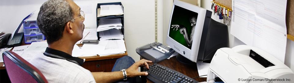 man sitting at a desk working at a computer