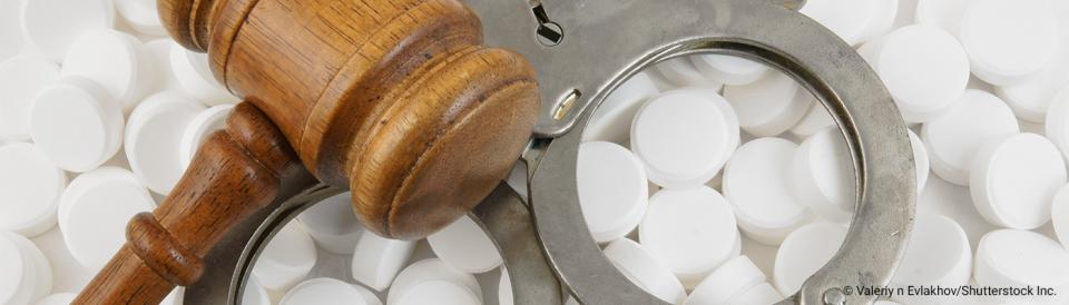 gavel, handcuffs and pills