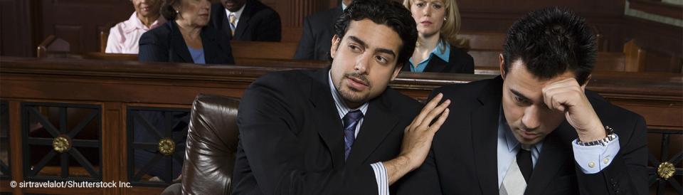 defendant being consoled by attorney in courtroom
