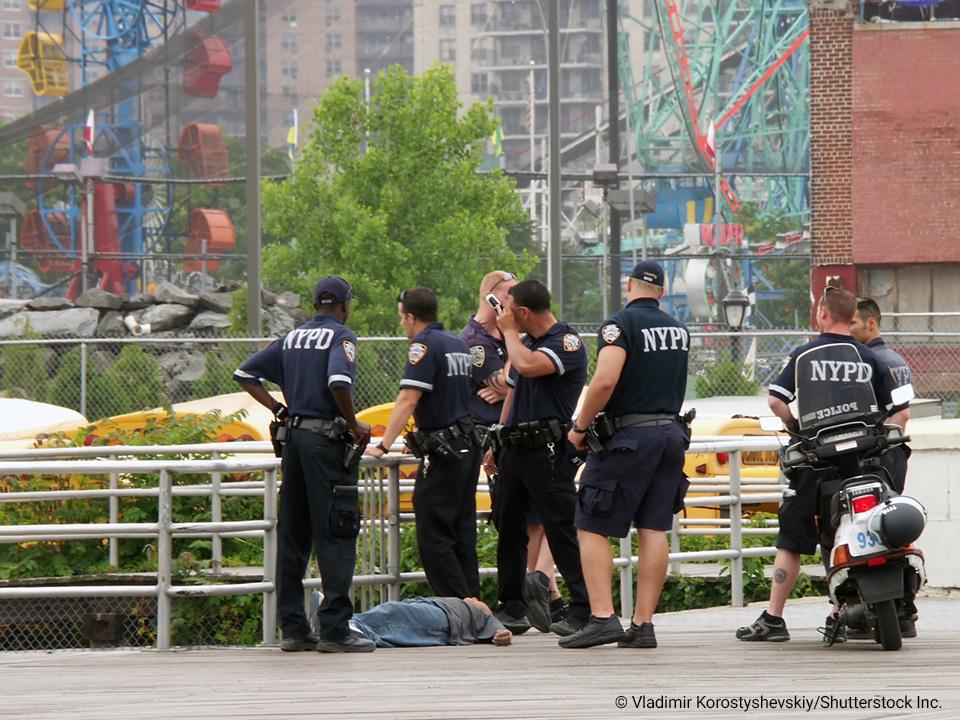 Officers at a crime scene with person lying on the ground