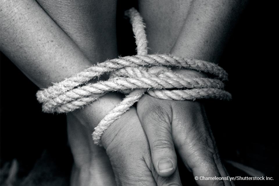 woman's hands and feet tied with rope