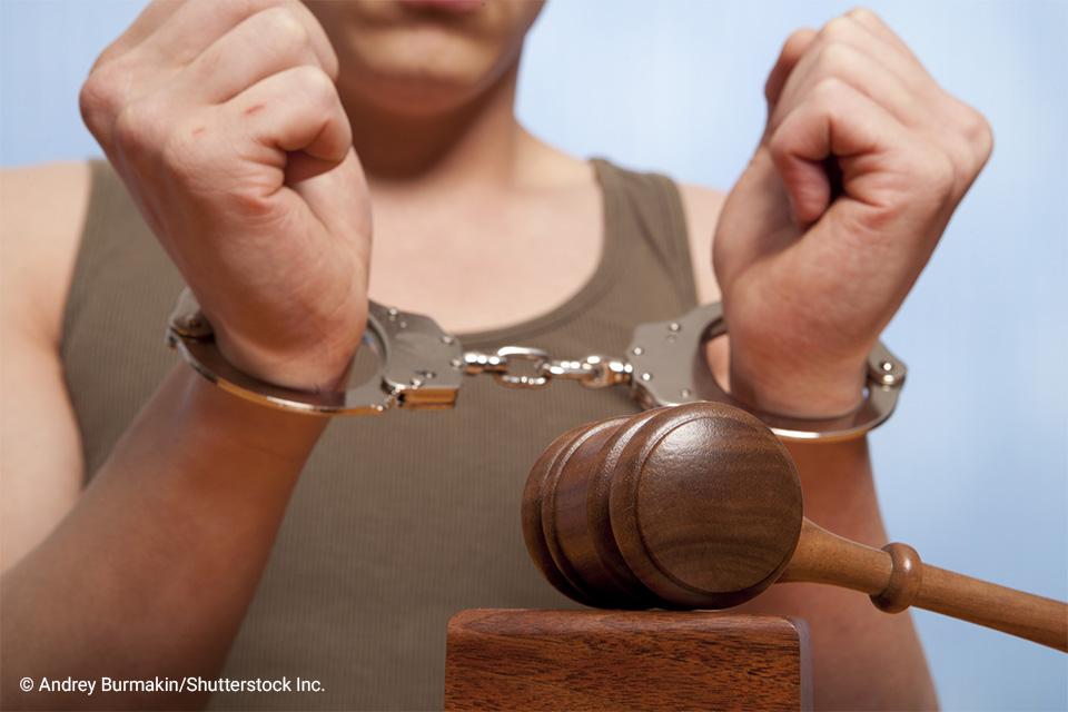 man in handcuffs net to a gavel