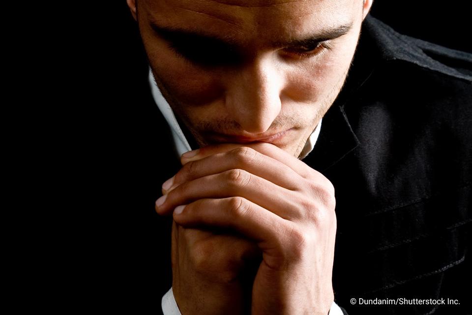man in a suit resting chin hands