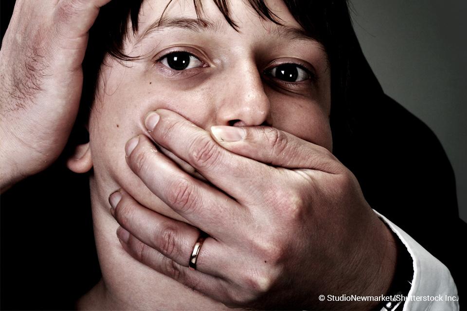 person being gagged by someone's hand