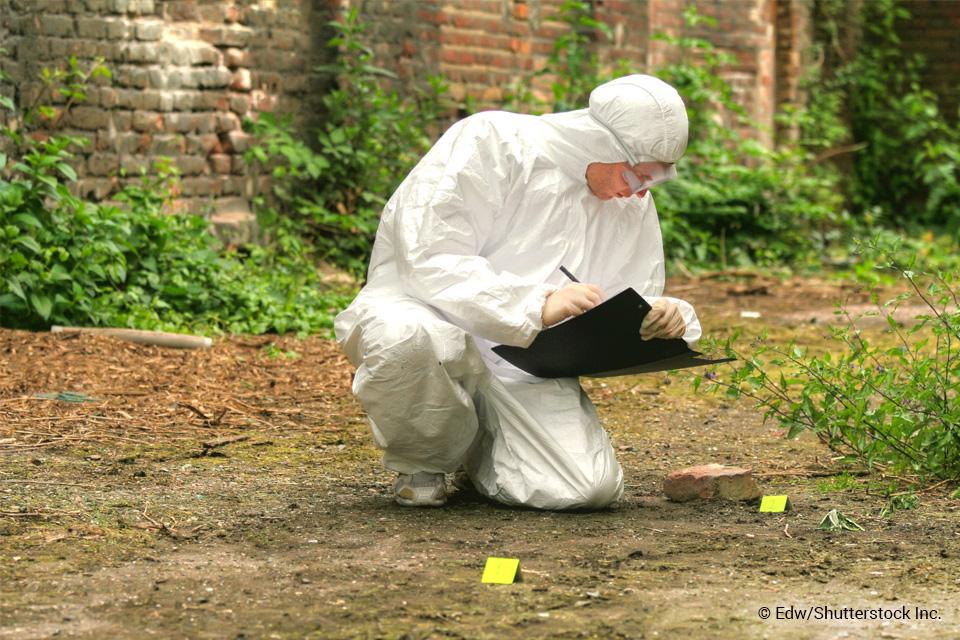 Crime scene technicial taking notes at outdoor scene