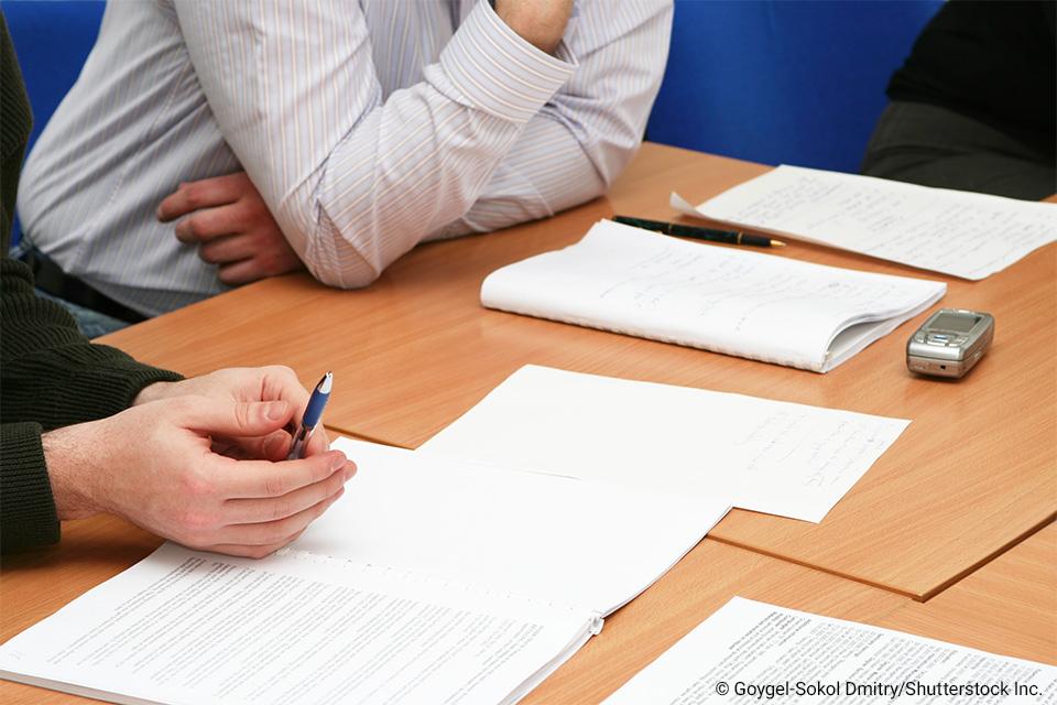 people at a desk looking over papers