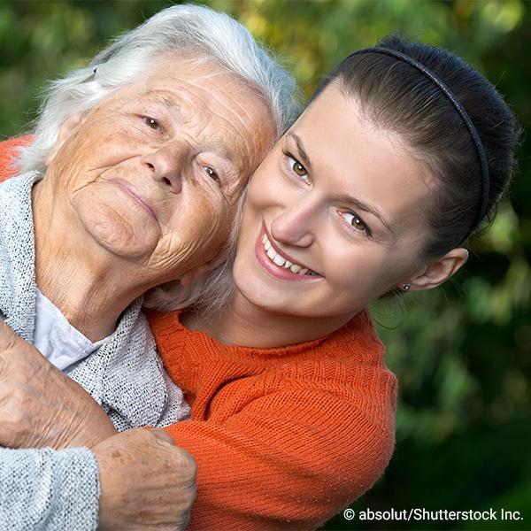 young and elderly woman embracing and smiling