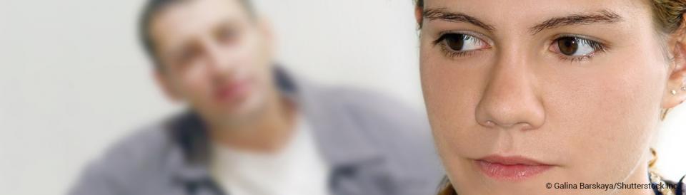 concerned young woman with man yelling in background