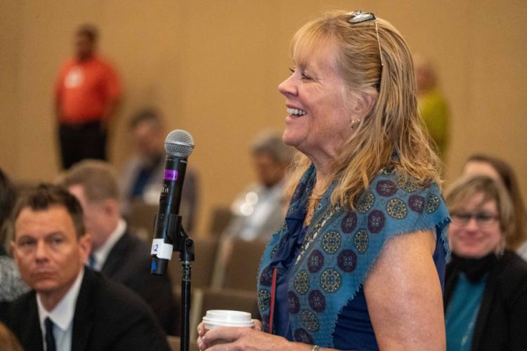 A conference attendee participants in Q&A after a plenary