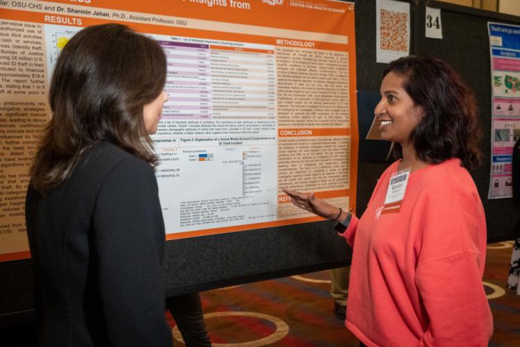 NIJ Director Nancy La Vigne chats with a poster presenter at the 2024 NIJ Research Conference