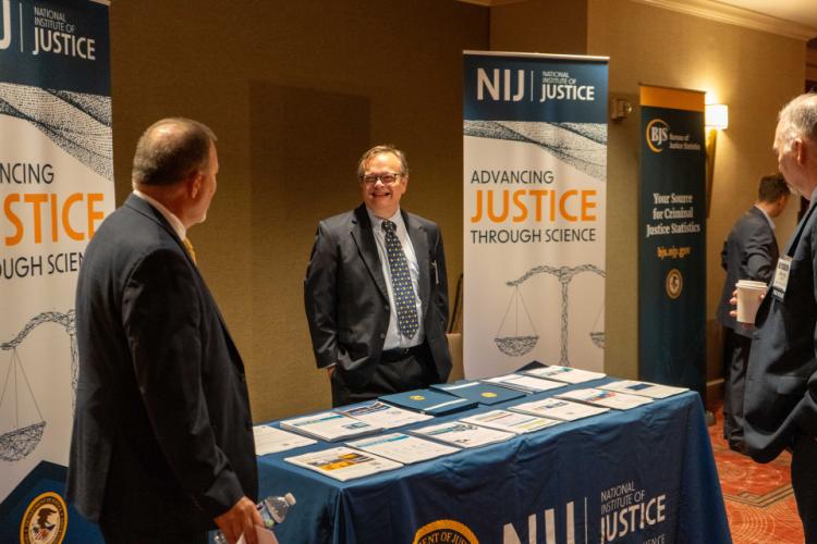 Conference attendees stop by the NIJ booth to learn more about key resources