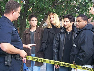 Photo of law enforcement officer separated from crowd by crime scene tape