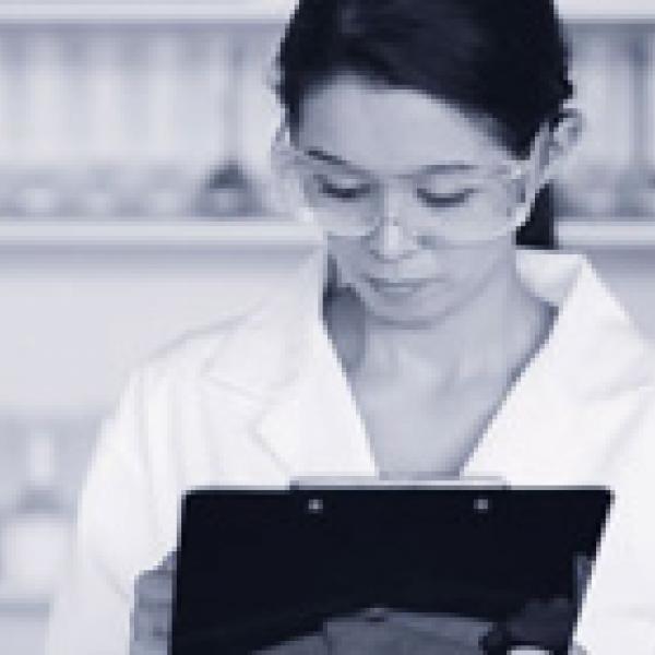 Female lab technician writing on a clipboard