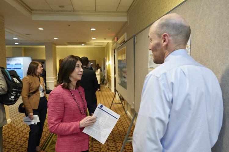 NIJ Director Nancy La Vigne talks with a poster session participant at the NIJ 2023 Research Conference